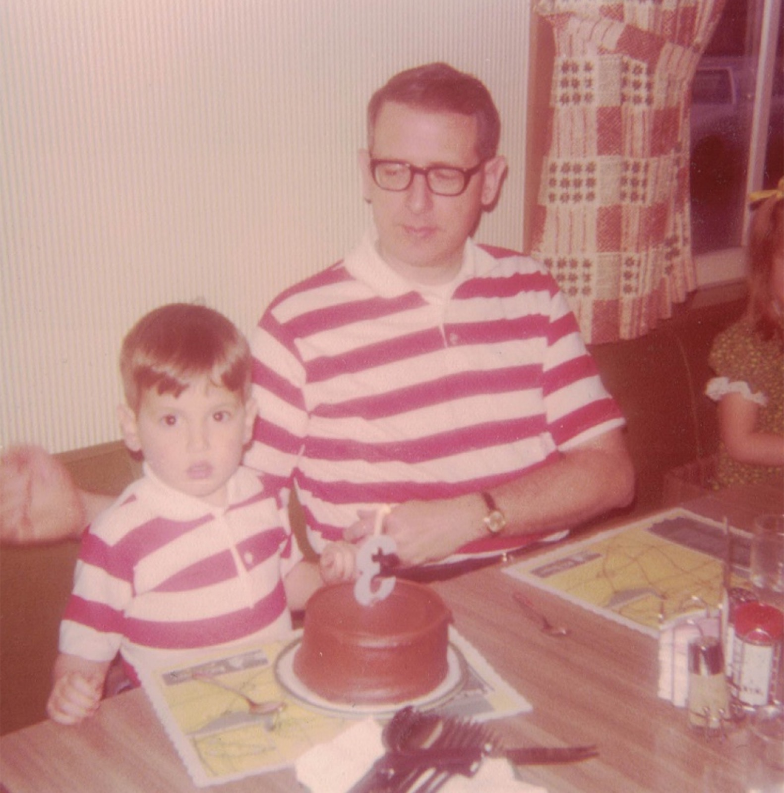 Dan cutting a birthday cake with son John